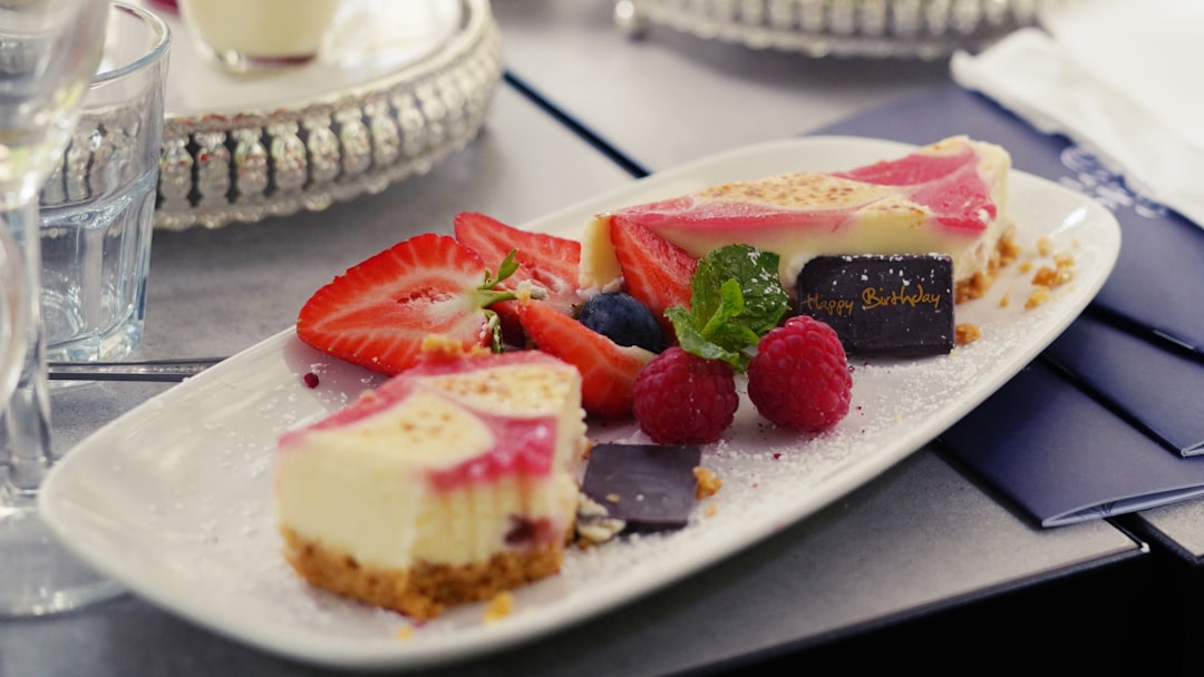 a-white-plate-topped-with-a-slice-of-cheesecake-covered-in-fruit-i7o948-baz4